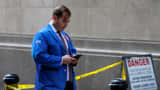 A trader uses his phone outside the New York Stock Exchange (NYSE) in New York.