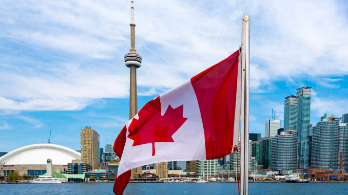 Una bandera canadiense ondea en medio del horizonte de Toronto