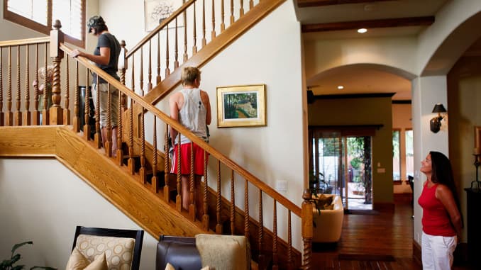 A real estate broker, right, gives a tour for potential home buyers during an open house in Manhattan Beach, California.