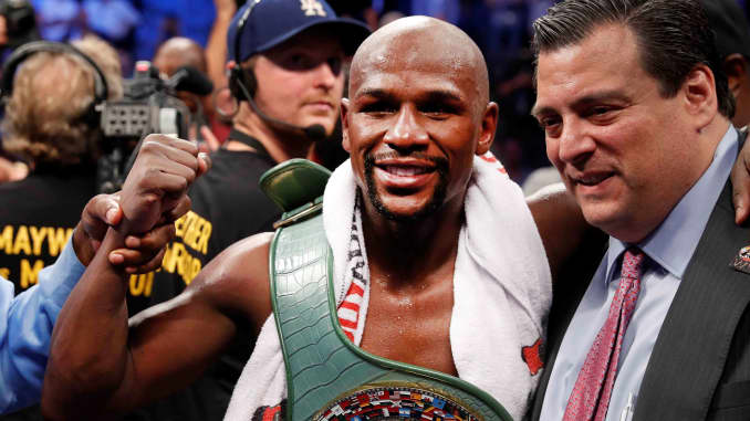 Floyd Mayweather Jr. celebrates with the belt and President of the WBC Mauricio Sulaiman after defeating Conor McGregor, August 26, 2017.