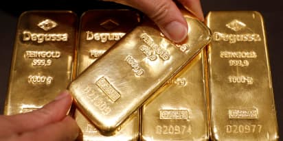 Gold hits highest in more than a week; dollar, stocks retreat
