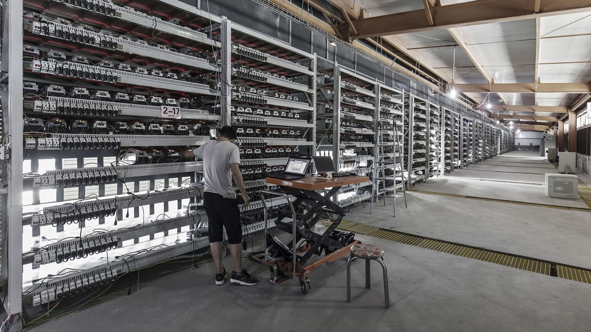 A technician inspects bitcoin mining machines at a mining facility operated by Bitmain Technologies Ltd. in Ordos, Inner Mongolia, China, on Friday, Aug. 11, 2017.