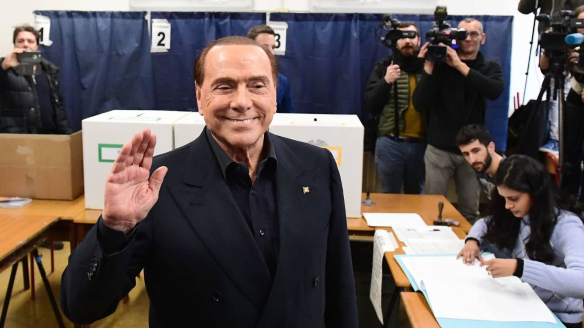 Silvio Berlusconi, leader of right-wing party Forza Italia, waves as he arrives to vote on March 4, 2018 at a polling station in Milan.