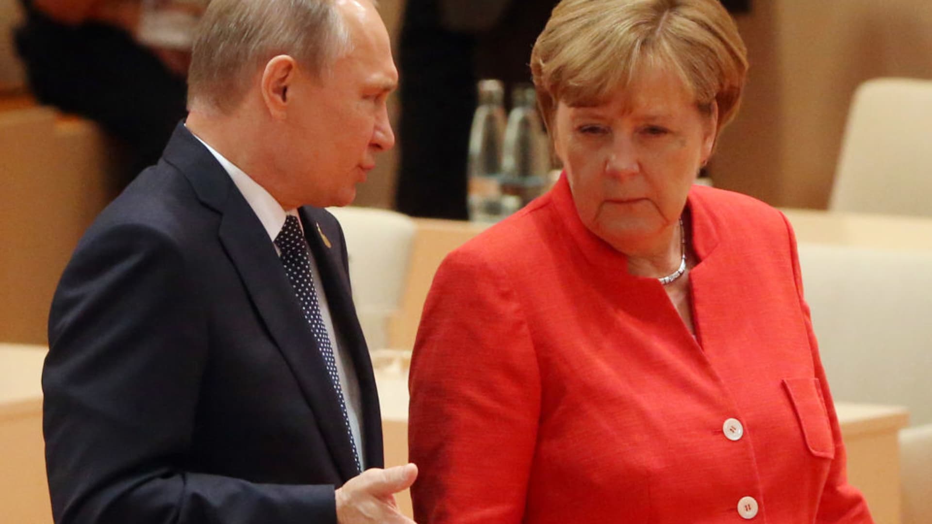 German Chancellor Angela Merkel (R) and Russian President Vladimir Putin (L) arrive to the plenary session at the G20 Summit on July 7, 2017.