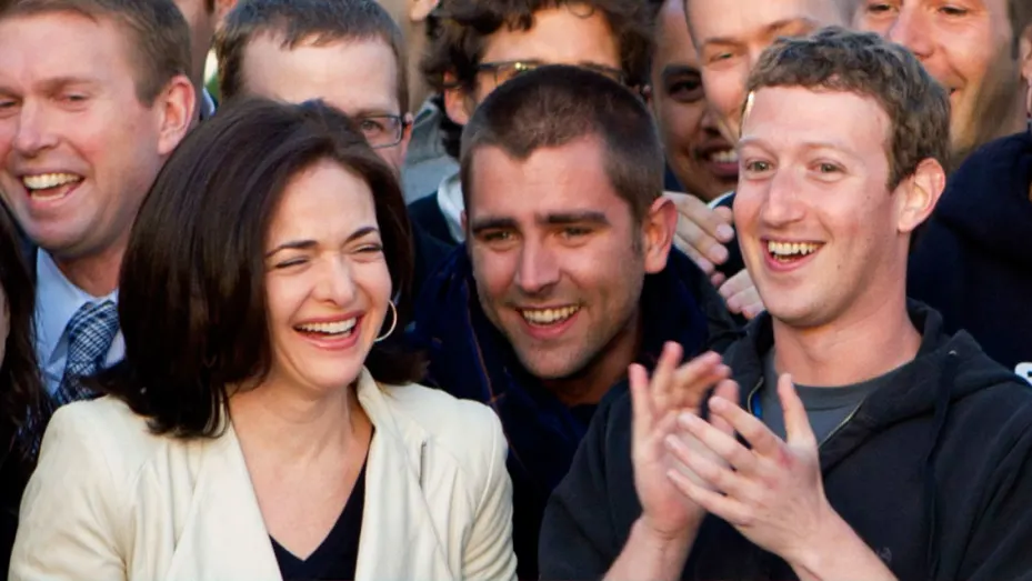Mark Zuckerberg, chief executive officer of Facebook Inc., right, Sheryl Sandberg, chief operating officer of Facebook, left, applaud after remotely ring the opening bell for trading at the Nasdaq MarketSite from the Facebook campus in Menlo Park, California