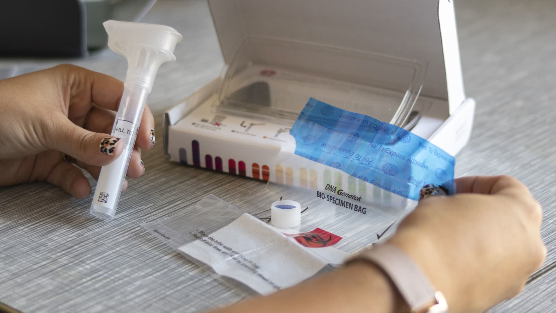 A reporter examines a 23andMe DNA genetic testing kit in Oakland, California.