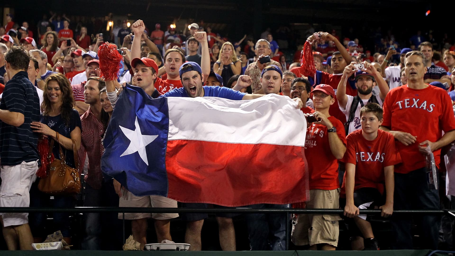 Fans of the Texas Rangers hold a Texas state flag at a game in Arlington, Texas.