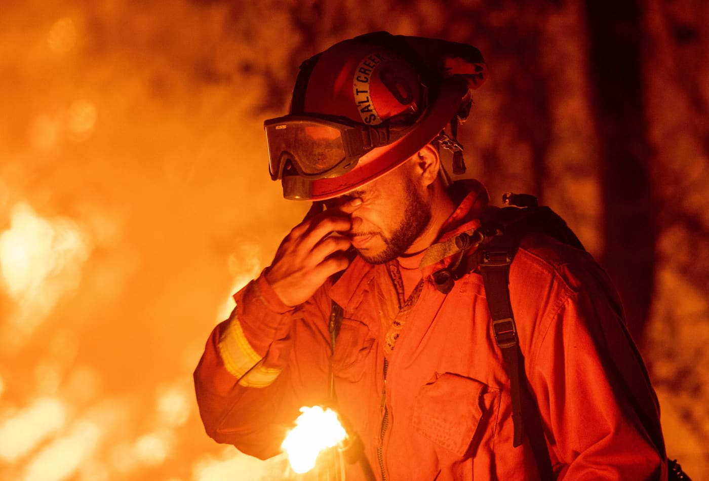 An inmate firefighter pauses during a firing operation as the Carr fire continues to burn in Redding, California on July 27, 2018. 
