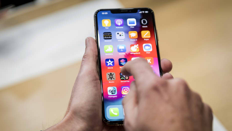 یکی از حاضران روز چهارشنبه 12 سپتامبر 2018 در رویدادی در تماشاخانه استیو جابز در کوپرتینو ، کالیفرنیا ، تلفن هوشمند Apple iPhone XR را نشان می دهد. 