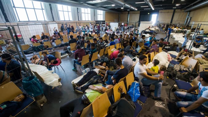 Refugees who arrived in Germany by crossing the nearby Austrian border wait in the waiting zone at the X-Point Halle initial registration center of the German federal police (Bundespolizei) on July 15, 2015 near Passau, Germany. 