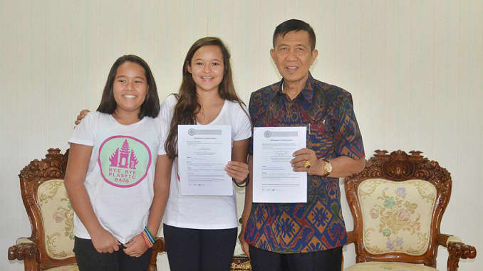Isabel and Melati Wijsen (left to right) with then-governor of Bali, Made Mangku Pastika, at the signing of their memorandum of understanding in 2014.