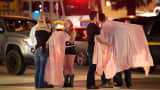 People comfort each other as they stand near the scene Thursday, Nov. 8, 2018, in Thousand Oaks, Calif. where a gunman opened fire Wednesday inside a country dance bar crowded with hundreds of people on "college night." 