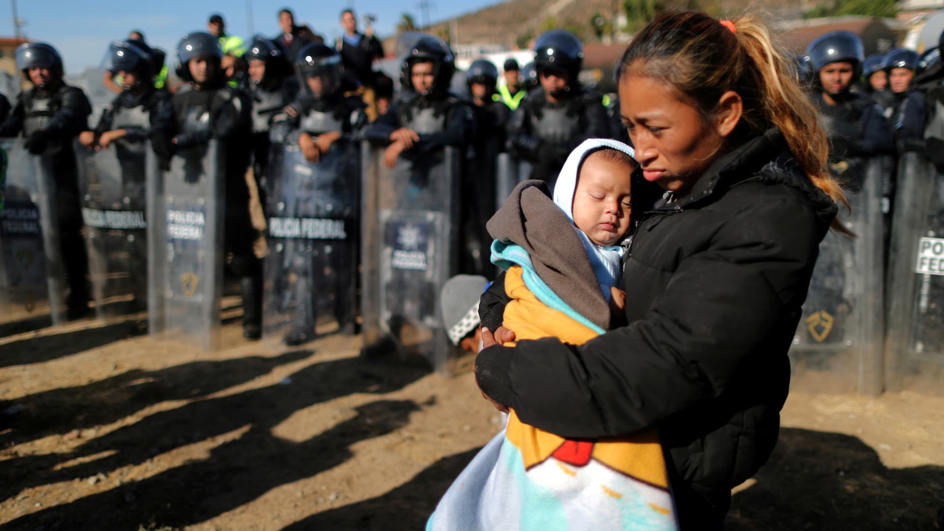 Rosa Villa, 30, and her five-month-old son Esteban from Honduras, part of a caravan of thousands traveling from Central America en route to the United States, are pushed back from the border wall between the U.S and Mexico by Mexican police in Tijuana, Mexico November 25, 2018.