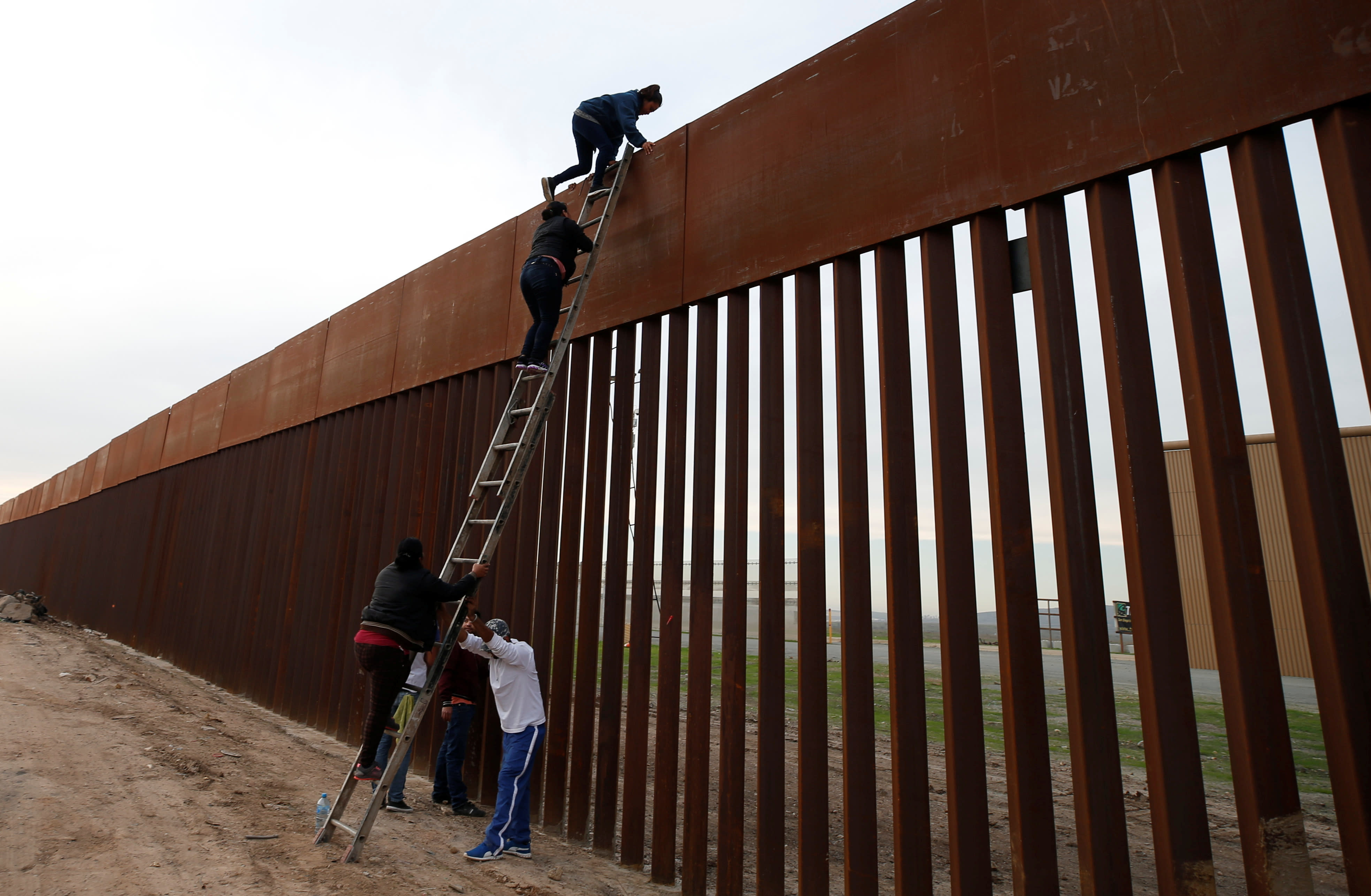 Забор держит воду. Стена на границе с Мексикой перелезают. Огромный забор. Забор на границе с Мексикой и США. Забор лесенкой.