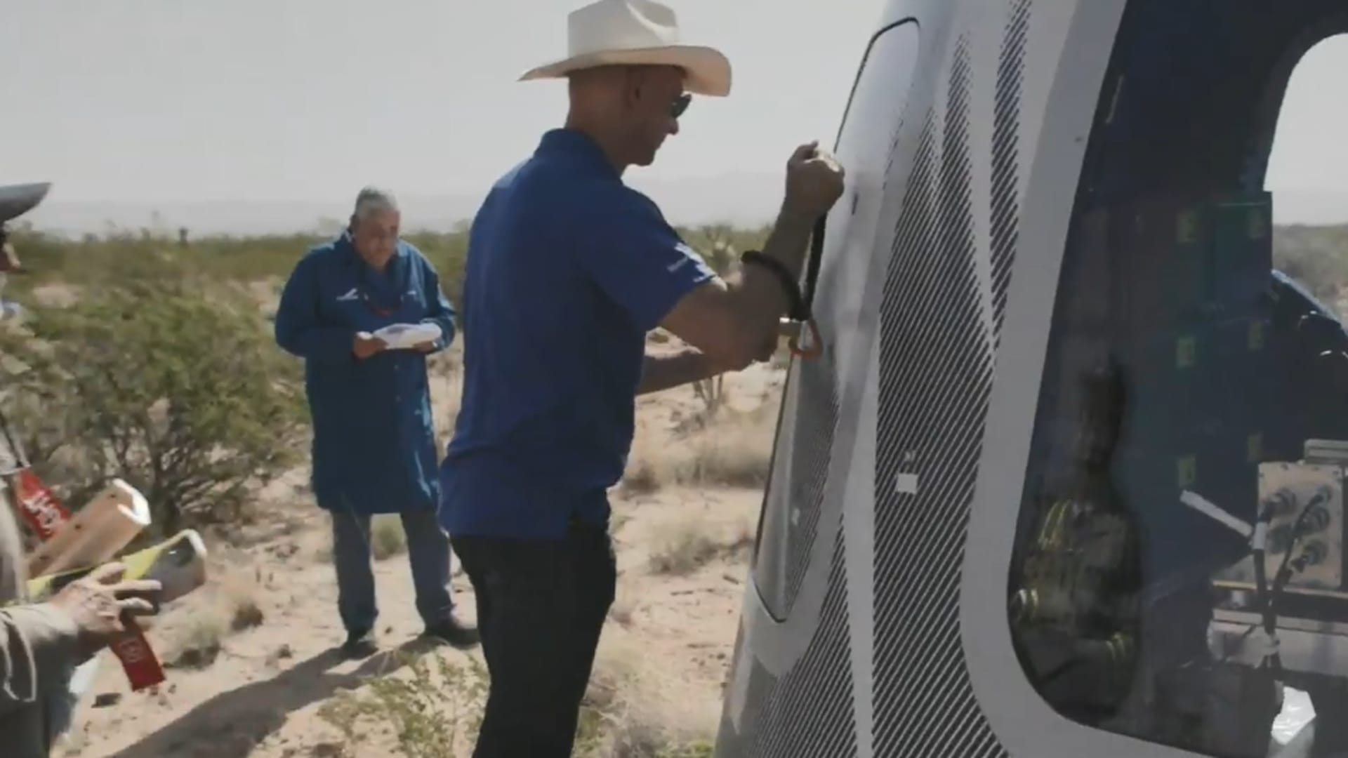 Blue Origin founder Jeff Bezos opens the capsule of the new Shepard Rocket after a launch.