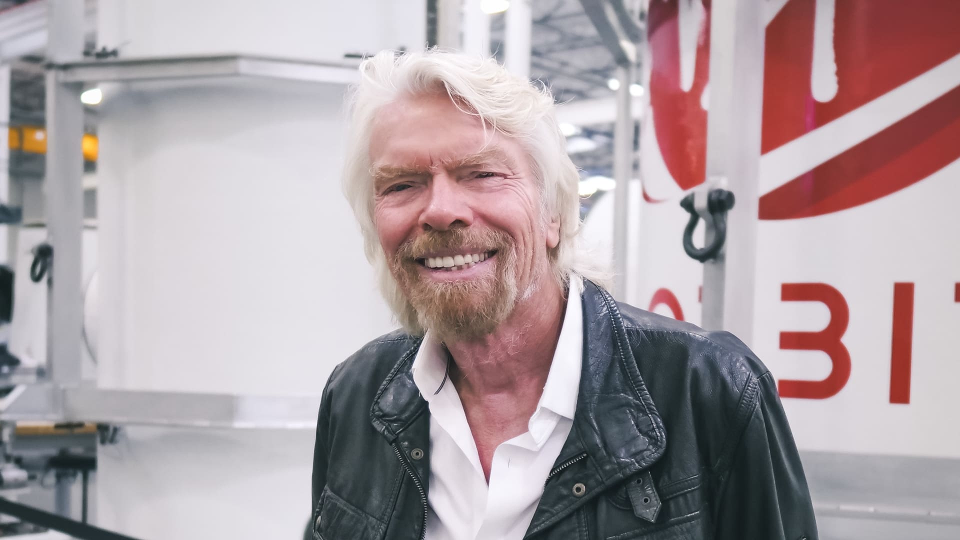 Sir Richard Branson poses in front of Virgin Orbit's rocket manufacturing.