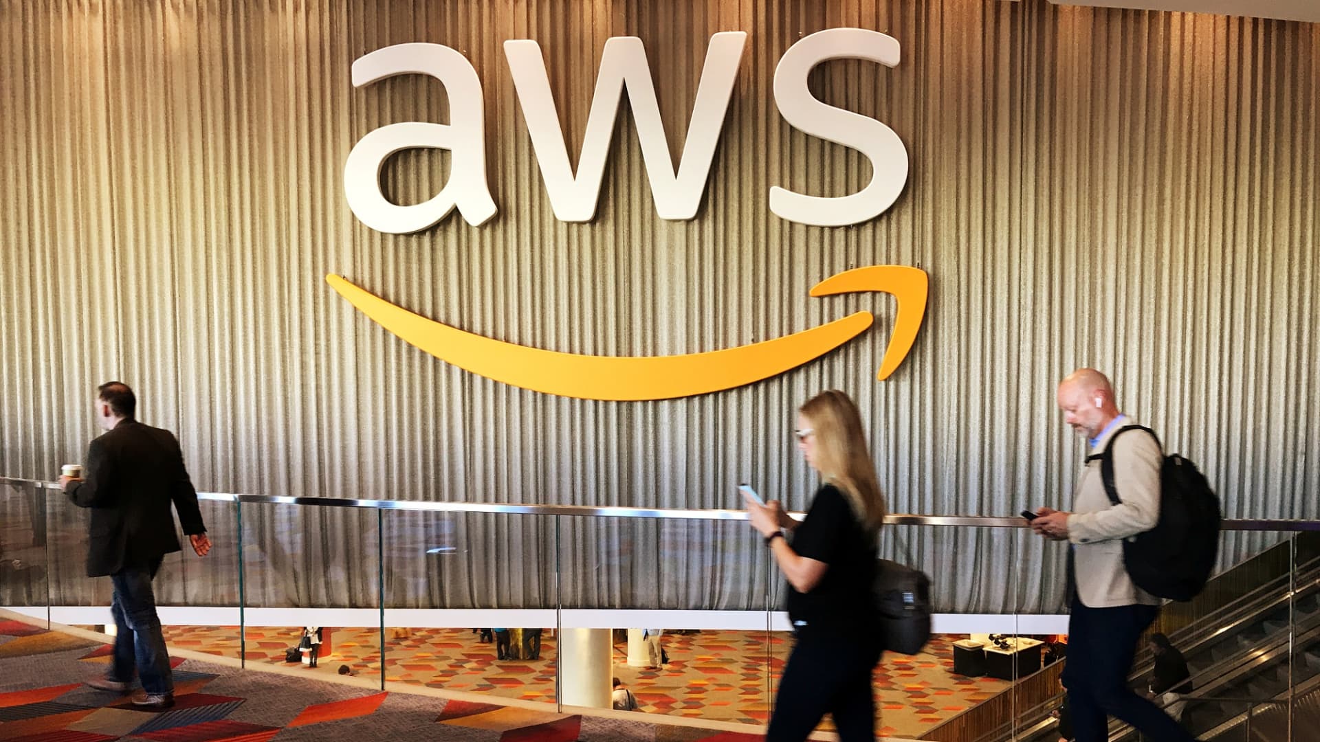 Attendees at Amazon.com Inc annual cloud computing conference walk past the Amazon Web Services logo in Las Vegas, Nevada, U.S., November 30, 2017.