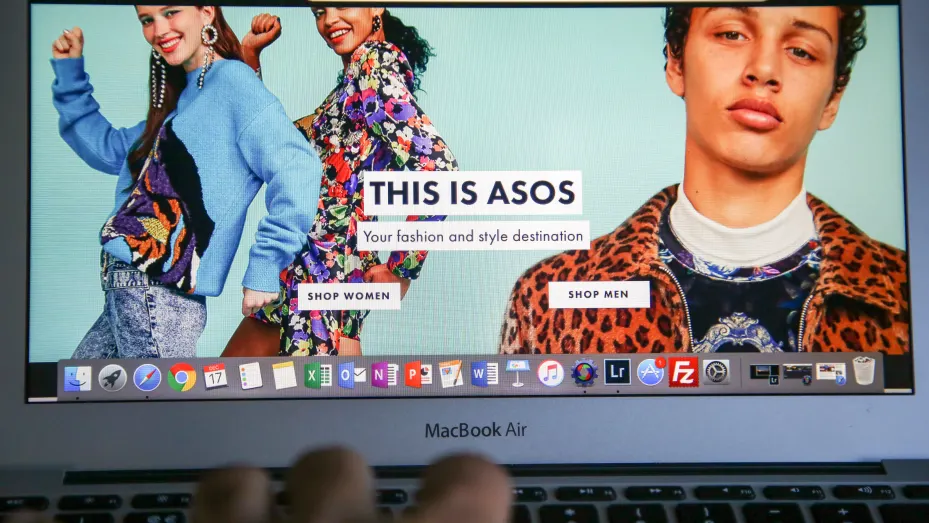 A woman is seen shopping on ASOS the online fashion store on a laptop.