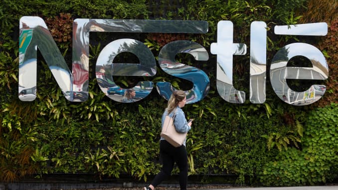 A pedestrian passes a Nestle SA logo at the Nescafe factory, operated by Nestle SA, in Tutbury, U.K., on Thursday, Aug. 23, 2018.