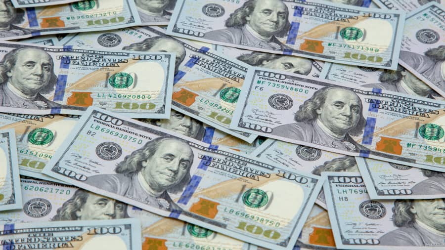 U.S. hundred dollar bills lie in a stash.