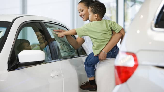 Woman and Son Looking at Car's Sticker Price