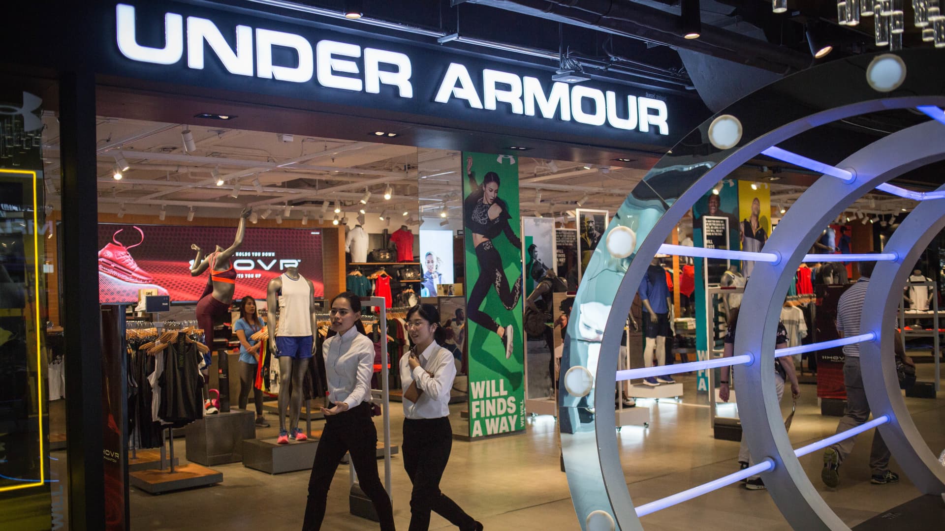 People walks past a Under Armour clothing store in Siam Center, Bangkok.