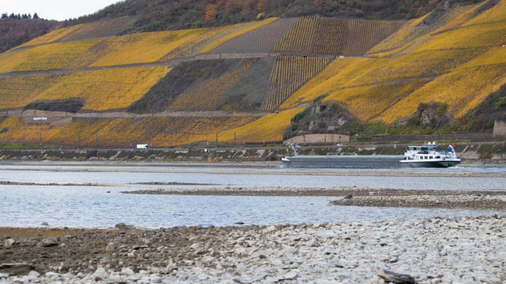 Half loaded cargo ships pass by the low water in the River Rhine along the vineyards on November 13, 2018 in Osterspai near Sankt Goarshausen, Germany. Summer heat wave in Germany as well unfavorable wind conditions, and no rain left the Rhine - which begins in the Swiss Alps, runs through Germany, and empties into the North Sea - at record low water levels.