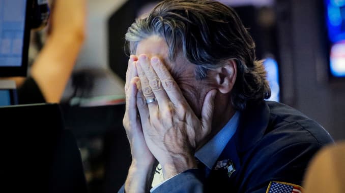 RT: manos de un operador de NYSE que cubren la cara Dow se hunde