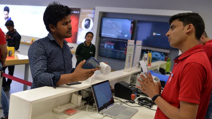 A salesman speaks with a customer after he purchased a new smartphone made by Xiaomi at a Mi store in Gurgaon, India, August 20, 2019.