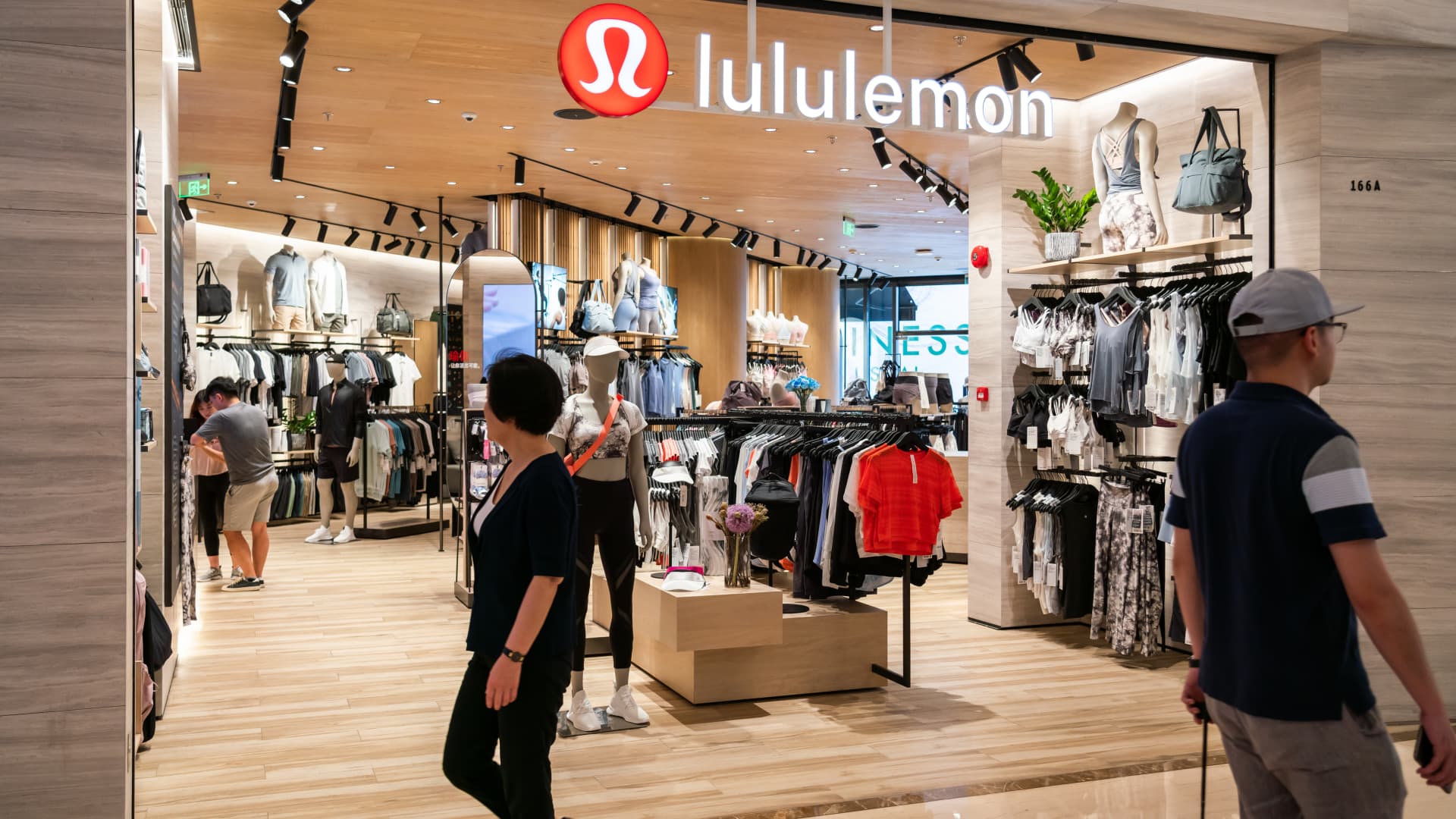 Pedestrians seen walking past Canadian athletic apparel retailer Lululemon in Shanghai.