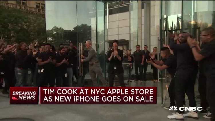Tim Cook opens the door at an NYC Apple Store as new iPhone goes on sale