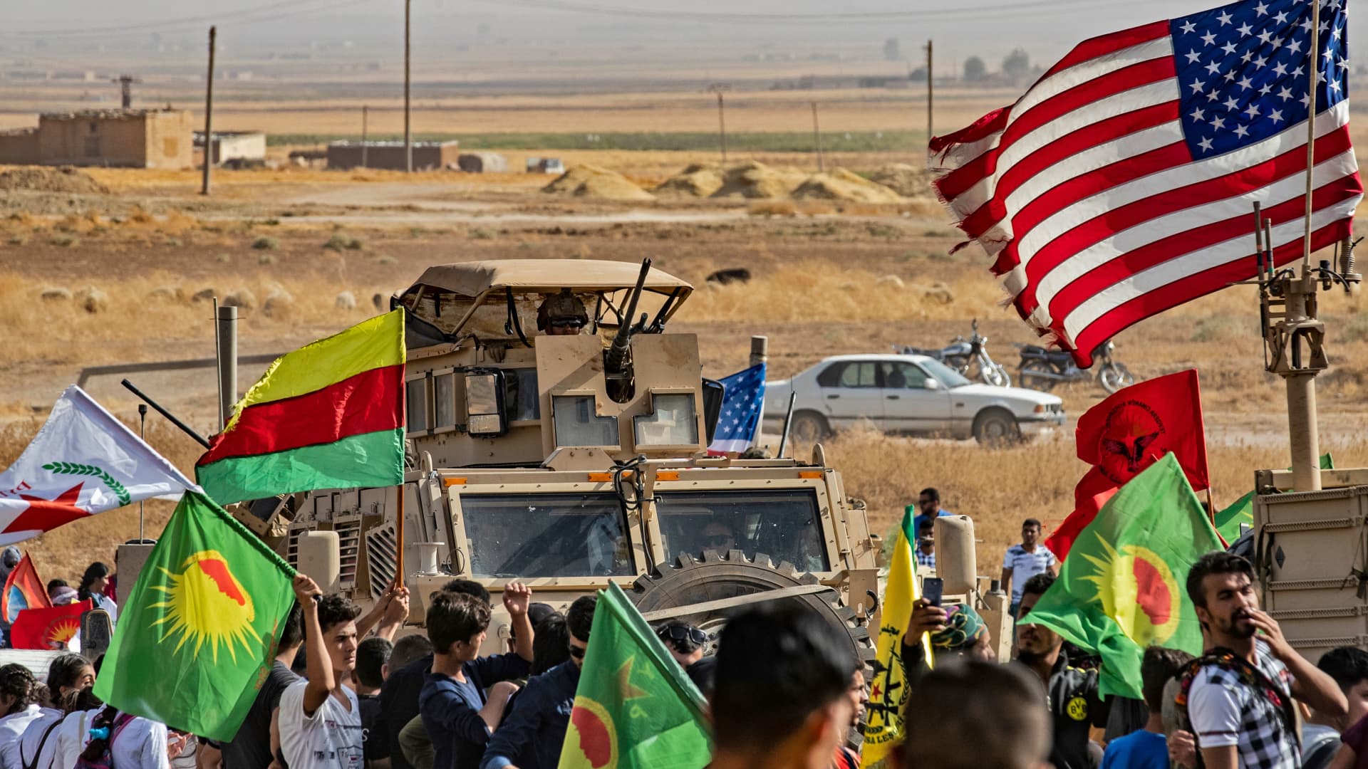 Syrian Kurds gather around a US armoured vehicle during a demonstration against Turkish threats next to a base for the US-led international coalition on the outskirts of Ras al-Ain town in Syria's Hasakeh province near the Turkish border on October 6, 2019.