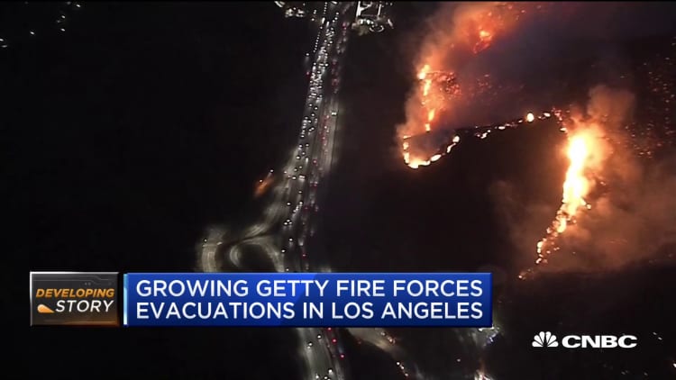 LA fire forces thousands to flee, shuts down main highway