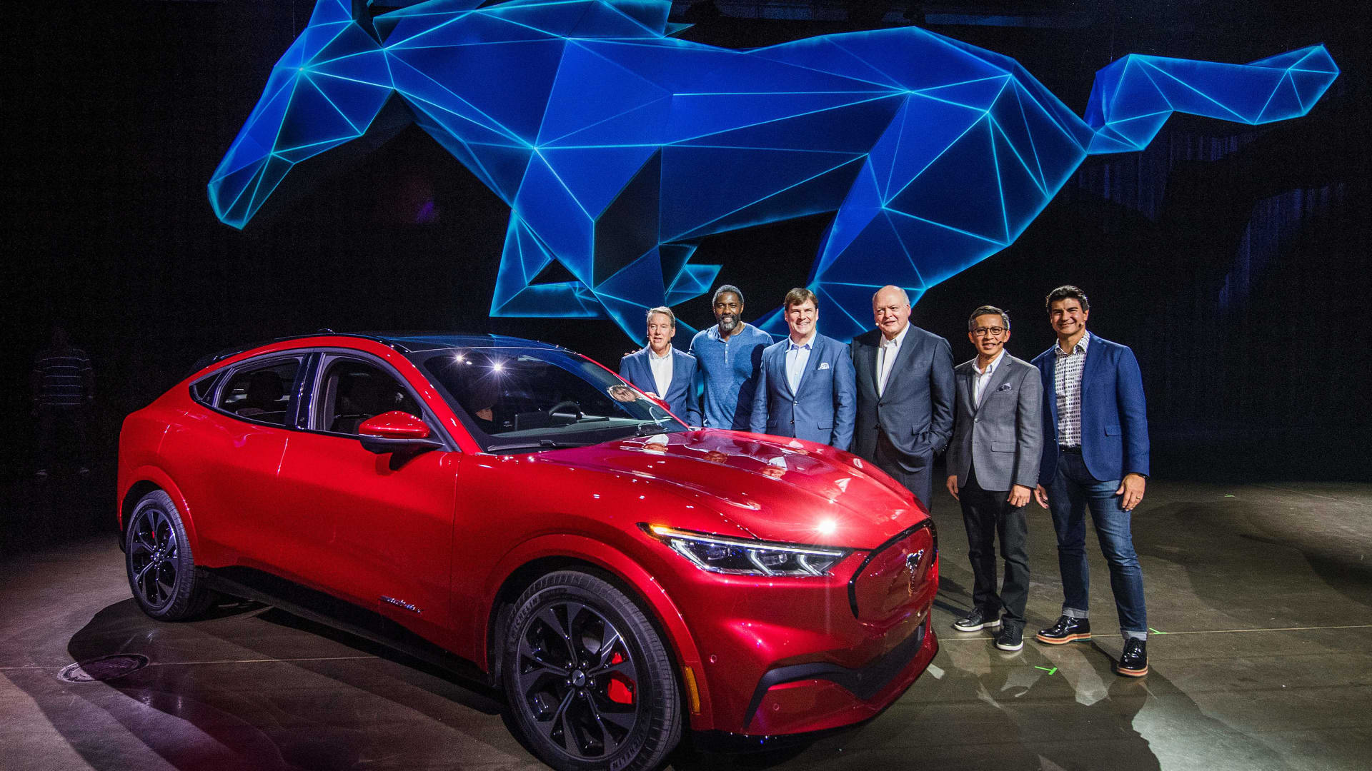 Then-Ford CEO James Hackett (3rd R) and team members, including his successor, Jim Farley (3rd L), reveal the company's first mass-market electric car the Mustang Mach-E, which is an all-electric vehicle that bears the name of the company's iconic muscle car at a ceremony in Hawthorne, California on November 17, 2019.