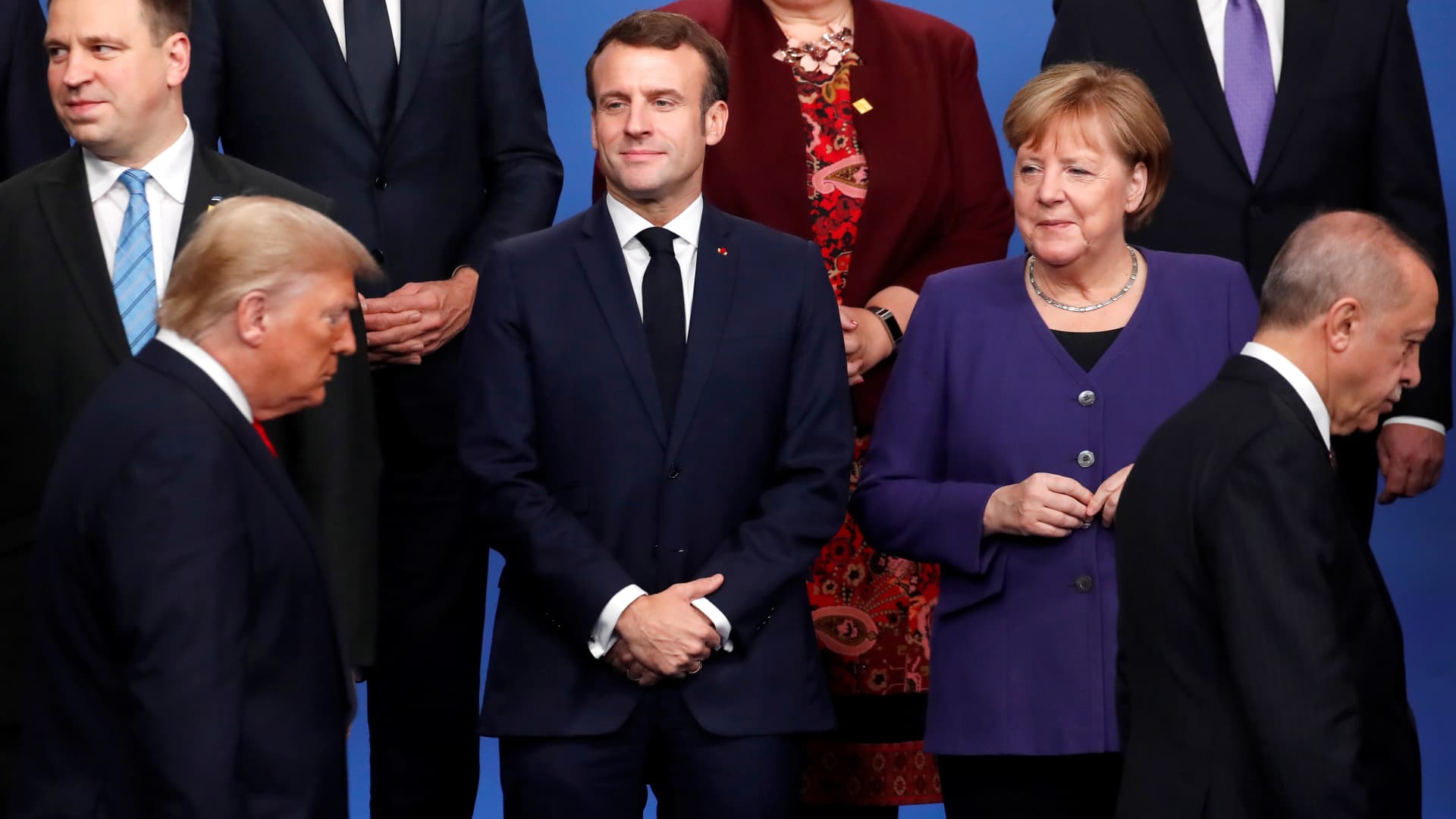 France's President Emmanuel Macron (2nd L) and Germany's Chancellor Angela Merkel (R) look at US President Donald Trump (front L) and Turkey's President Recep Tayyip Erdogan (front R) walking past them during a family photo as part of the NATO summit at the Grove hotel in Watford, northeast of London on December 4, 2019.