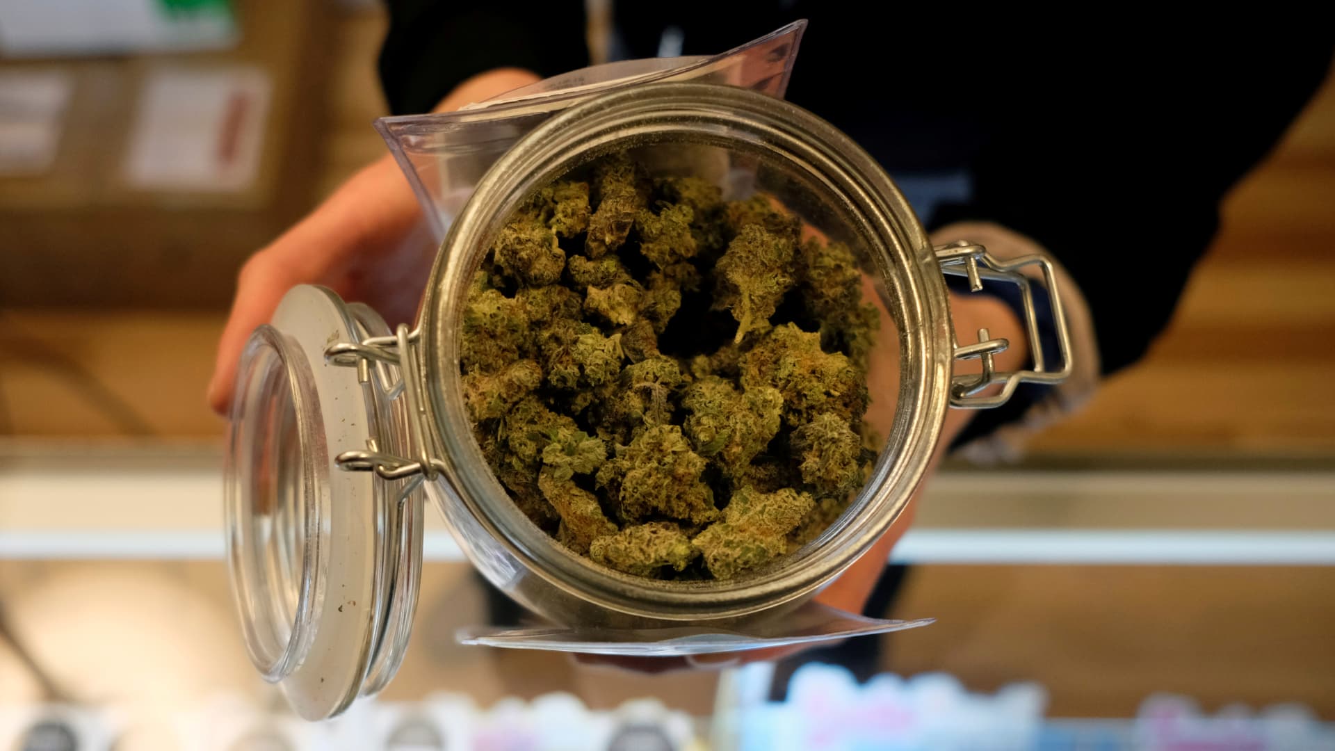 An employee holds a jar of marijuana on sale after it became legal in the state to sell recreational marijuana to customers over 21 years old in Ann Arbor, Michigan. Illinois begins the legal sale of marijuana on Jan 1, 2020.