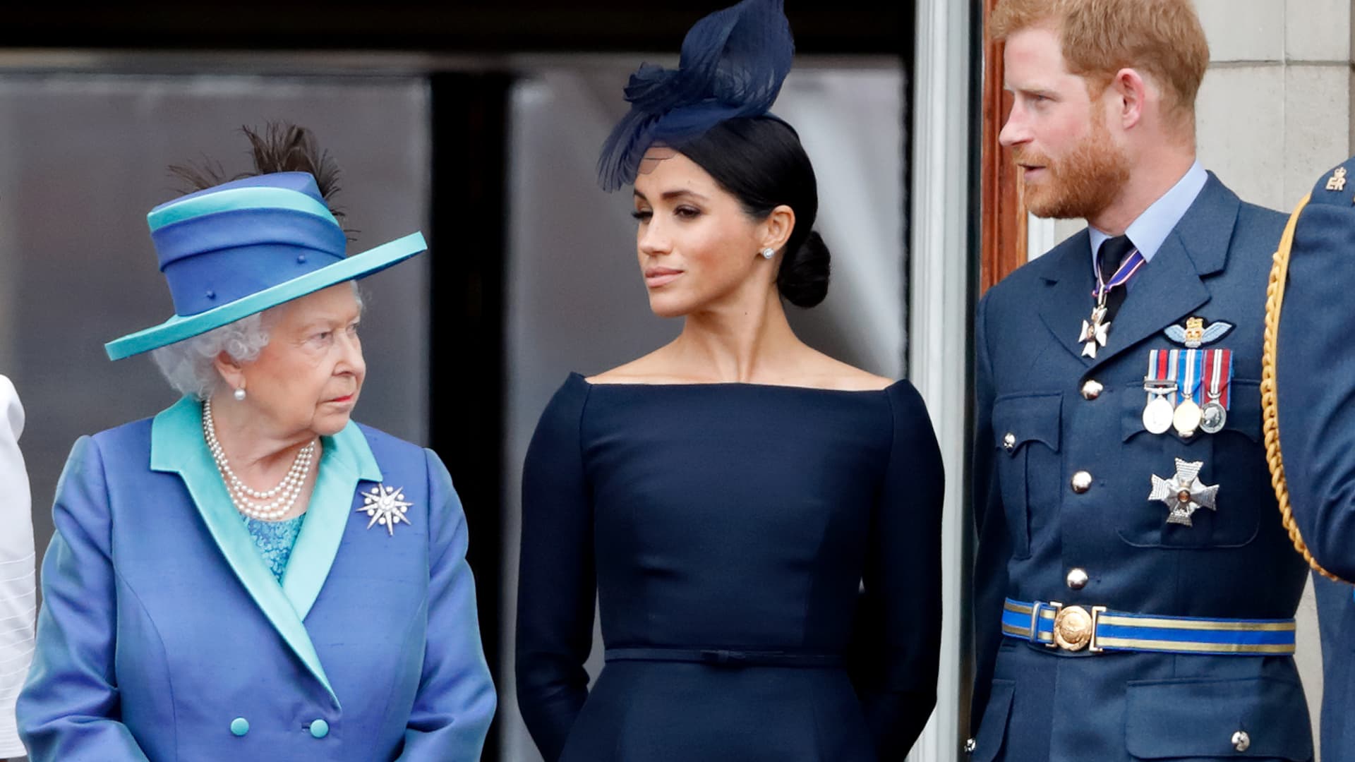 Queen Elizabeth II, Meghan, Duchess of Sussex and Prince Harry, Duke of Sussex watch a flypast to mark the centenary of the Royal Air Force from the balcony of Buckingham Palace on July 10, 2018 in London, England.