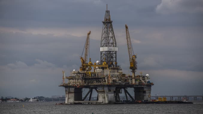 A kayaker passes in front of an offshore oil platform in the Guanabara Bay in Niteroi, Brazil, Saturday, Feb. 1, 2020.