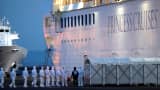 Officers in protective gear enter the cruise ship Diamond Princess, where 10 more people were tested positive for coronavirus on Thursday, to transfer a patient to the hospital after the ship arrived at Daikoku Pier Cruise Terminal in Yokohama, south of Tokyo, Japan February 7, 2020.