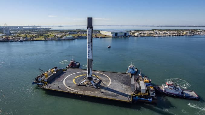 A SpaceX Falcon 9 rocket booster is towed back in to Port Canaveral after landing on the company's barge.
