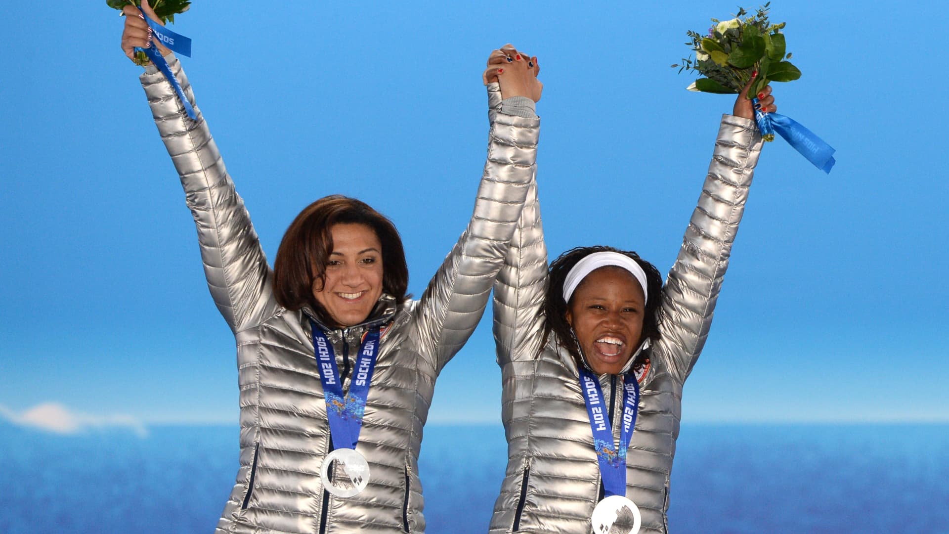 A picture taken with a robotic camera shows US silver medalists pilot Elana Meyers and brakewoman Lauryn Williams celebrating during the Women's Bobsleigh Medal Ceremony at the Sochi medals plaza during the Sochi Winter Olympics on February 20, 2014.