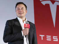 Tesla Motors CEO Elon Musk speaks to the media next to its Model S.