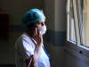A medical worker wearing a face mask talks on her mobile phone inside the new coronavirus intensive care unit of the Brescia Poliambulanza hospital, Lombardy, on March 17, 2020.