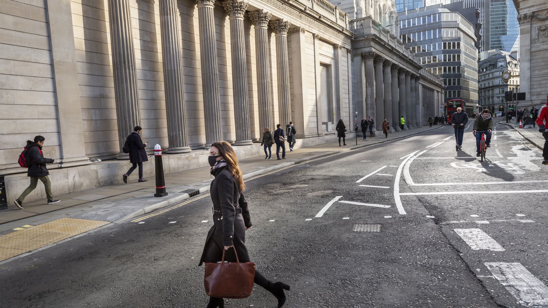 A woman wearing a protective face mask crosses the road in front of the Bank of England in what would normally be the morning rush hour in the City of London on March 17th, 2020. The financial district of the UK is unusually quiet after the government requested people to refrain from all but essential travel and activities yesterday.