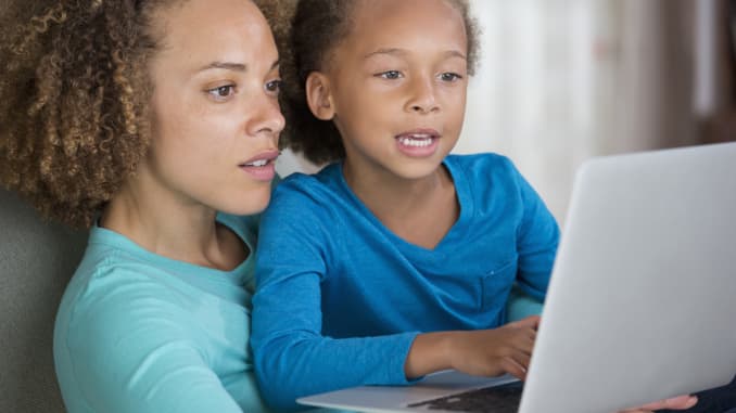 GP: Black mother and daughter using laptop