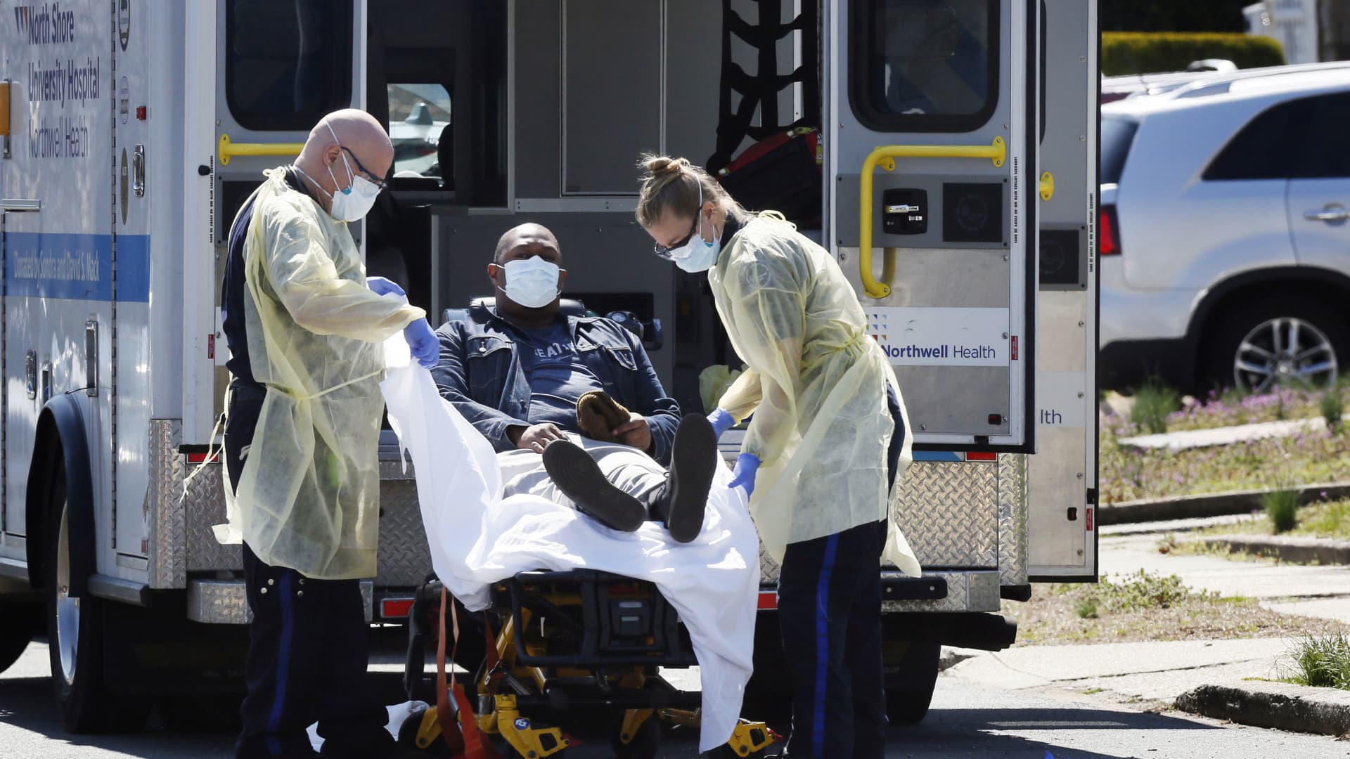 Emergency Medical Technicians (EMT) lift a patient that was identified to have coronavirus disease (COVID-19) into an ambulance while wearing protective gear, as the outbreak of coronavirus disease (COVID-19) continues, in New York City, New York, U.S., March 26, 2020.