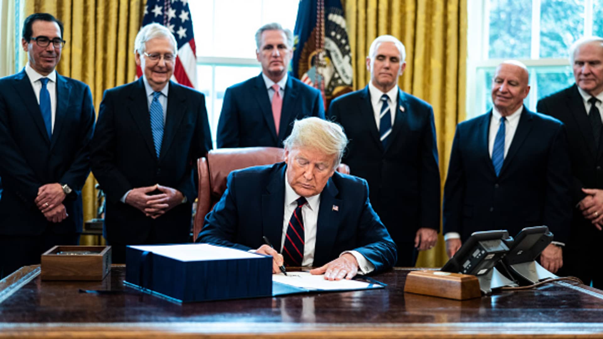 U.S. President Donald Trump signs H.R. 748, the CARES Act in the Oval Office of the White House on March 27, 2020 in Washington, DC.