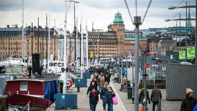 People walk at Strandvagen in Stockholm on March 28, 2020, during the the new coronavirus COVID-19 pandemic. - Sweden, which has stayed open for business with a softer approach to curbing the COVID-19 spread than most of Europe, on March 27, 2020 limited gatherings to 50 people, down from 500.