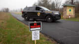 A Maryland State Trooper guards the driveway to the Pleasant View Nursing Home, in Mount Airy, Md., Sunday, March 29, 2020, by a sign that says "no trespassing" that was put up by the Carroll County Health Department. COVID-19.