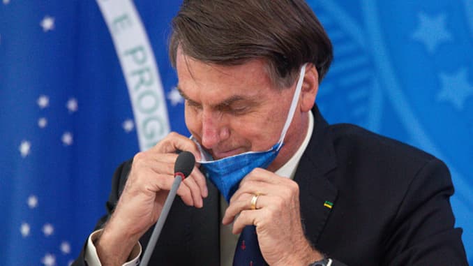 Jair Bolsonaro President of Brazil takes off his protective mask to speak to journalists during a press conference about outbreak of the coronavirus (COVID – 19) at the Planalto Palace on March 20, 2020 in Brasilia, Brazil. Andressa Anholete | Getty Images